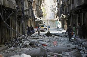 Residents walk on rubble in a damaged street in Aleppo's district of Bustan al-Basha